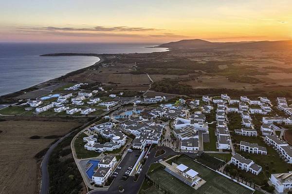 Sonnenuntergang über der Bucht des Club Plimmiri Hotels mit Blick auf das Meer und die umliegenden Gebäude.