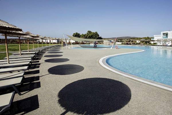 Außenpoolbereich des Club Plimmiri Hotels mit Sonnenliegen und Sonnenschirmen