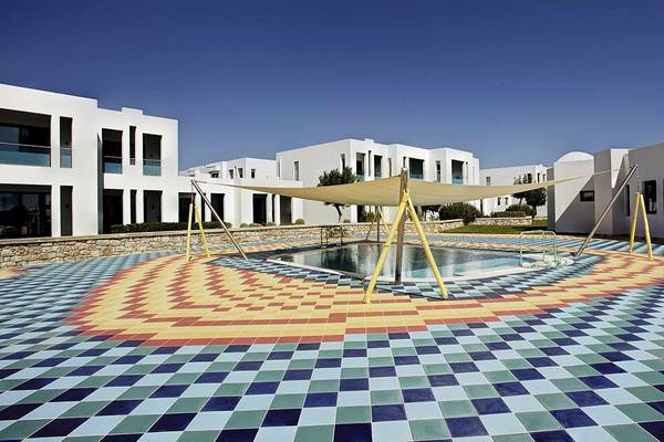 Außenpoolbereich des Club Plimmiri Hotels mit bunten Fliesen und Sonnensegel.
