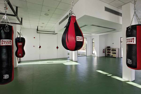 Fitnessraum im Club Plimmiri Hotel mit mehreren Boxsäcken und einer grünen Trainingsfläche.