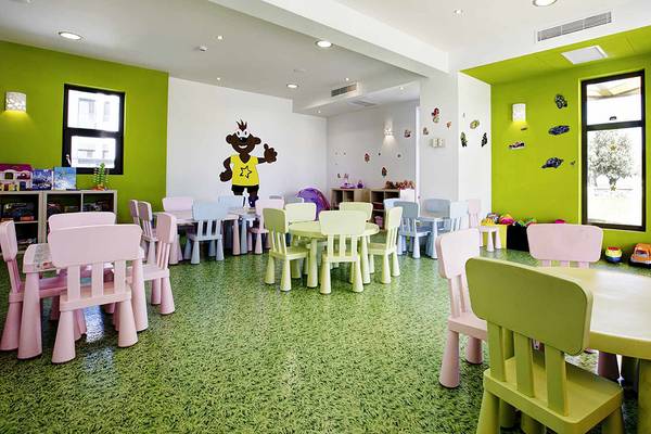 Kinderspielzimmer im Club Plimmiri Hotel mit grünen Wänden, bunten Möbeln und Spielsachen.