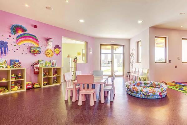Kinderzimmer im Club Plimmiri Hotel mit bunten Wänden, Spielzeug und Spielbereich.