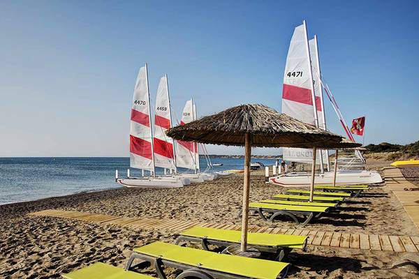 Segelboote und Sonnenliegen am Strand des Club Plimmiri Hotels.