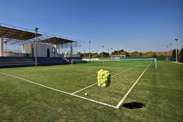 Tennisplatz des Club Plimmiri Hotels mit leeren Bänken und einem Ballkorb auf dem Feld