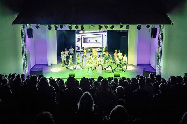 Tanzveranstaltung im Club Plimmiri mit einer Gruppe von Tänzern auf der Bühne vor einem Publikum.