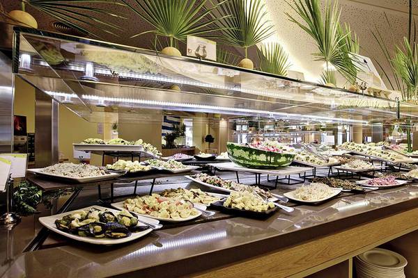 Buffet-Tisch im Club Plimmiri Hotel mit vielen verschiedenen Gerichten auf weißen Tellern.