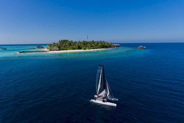 Luftaufnahme eines Segelboots vor der Insel des Outrigger Maldives Maafushivaru Resorts
