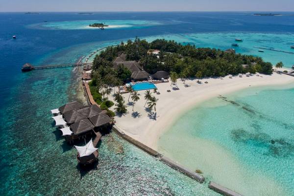 Luftaufnahme des Outrigger Maldives Maafushivaru Resorts mit Strand, Gebäuden und Swimmingpool.