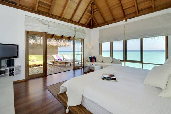 Schlafzimmer im Outrigger Maldives Maafushivaru Resort mit Blick auf den Ozean