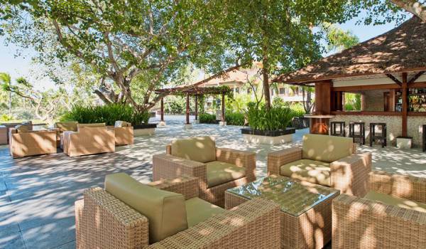 Lounge-Bereich im Freien des Laguna Luxury Collection Resorts mit Rattan-Möbeln und einer Bar.