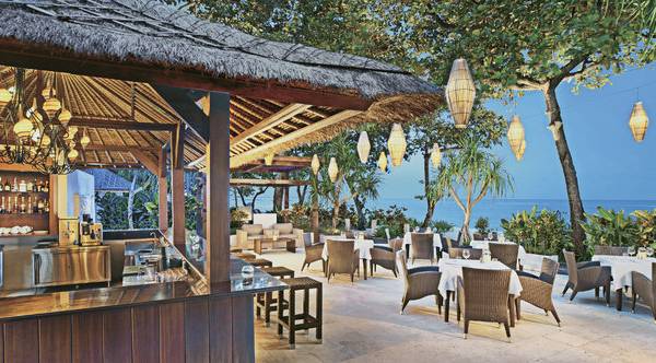 Außenbereich des Laguna a luxury Collection Resort & Spa mit Bar, Tischen und Stühlen am Meer.