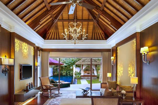 Innenansicht des Wohnbereichs im Laguna Collection Resort & Spa mit moderner Einrichtung und offenen Türen zu einem Pool.