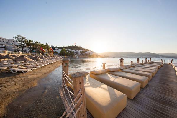 Terrasse des Salmakis Resort & Spa mit Blick auf den Strand und das Meer bei Sonnenuntergang