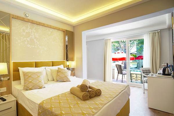 Luxuriöses Schlafzimmer im Selectum Family Comfort Side mit gelbem Bett, Spiegel und gerollten Handtüchern.