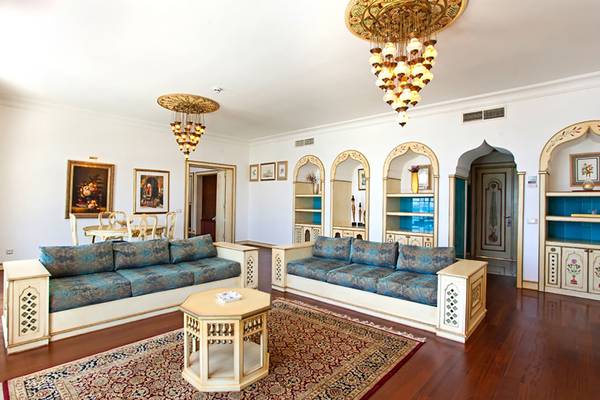 Wohnzimmer im Salmakis Resort & Spa mit zwei blauen Sofas, einem Tisch und Kronleuchtern.