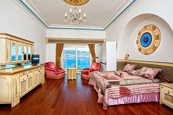Innenansicht eines Schlafzimmers im Salmakis Resort & Spa mit Blick auf das Meer