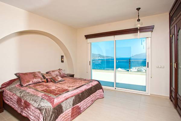 Schlafzimmer mit Meerblick im Salmakis Resort und Spa, mit einem großen Bett und einer Terrassentür.