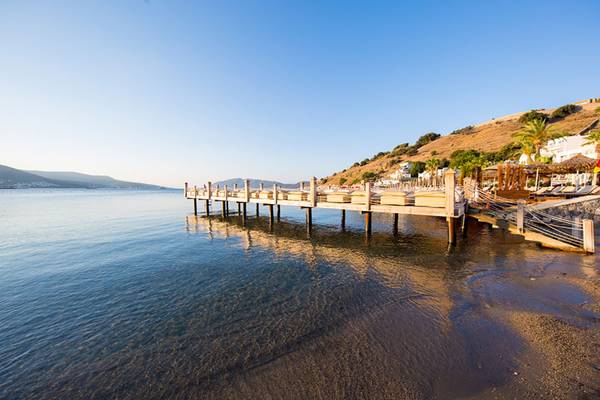 Pier am Wasser vom Salmakis Resort & Spa mit Blick auf das Meer und die Hügel