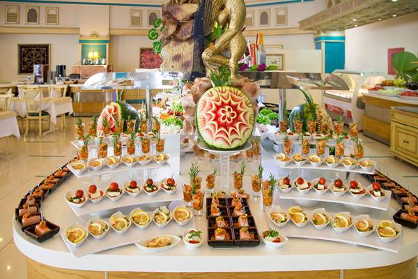 Buffet im Salmakis Resort & Spa mit verschiedenen Gerichten, Wassermelonen und Dekoration.