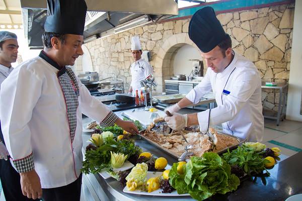 Küchenteam im Salmakis Resort & Spa bereitet ein Fischgericht zu.