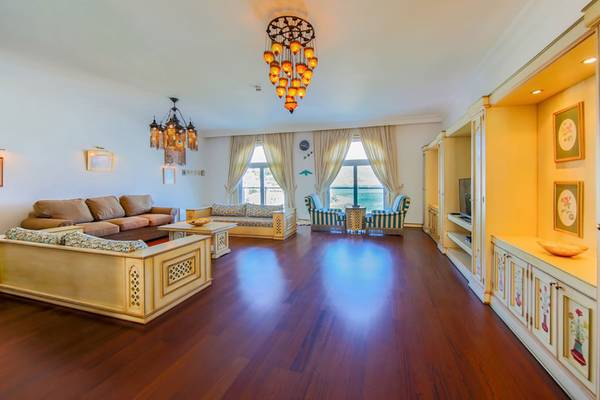 Das geräumige Wohnzimmer des Salmakis Resort & Spa mit Sofas, einem Tisch und einem Kronleuchter.