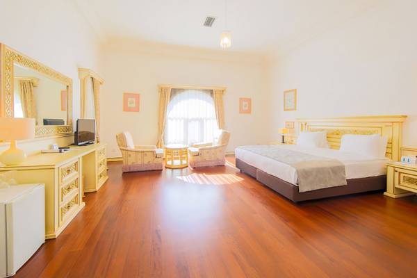 Hotelzimmer im Salmakis Resort & Spa mit großem Bett, Möbeln und Dekoration.