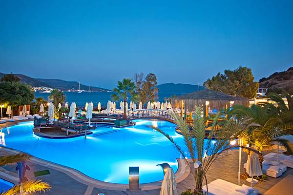 Salmakis Resort & Spa Pool am Abend mit Blick auf das Meer und Berge