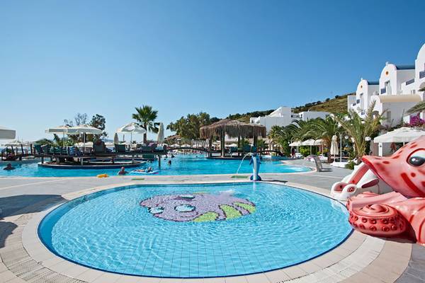 Pool im Salmakis Resort & Spa mit großer Oktopus-Skulptur und Sonnenschirmen.