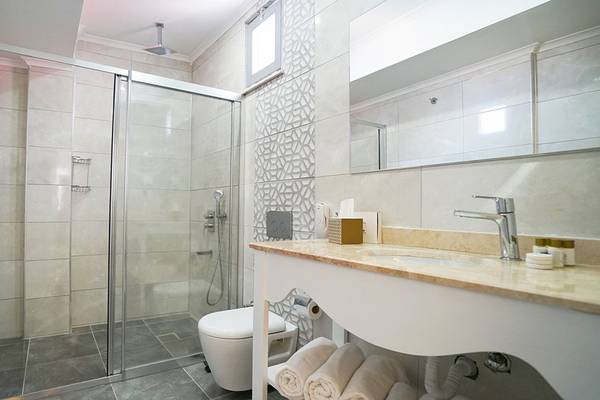 Badezimmer des Selectum Family Comfort Side Hotels mit Dusche, Toilette und Waschbecken.
