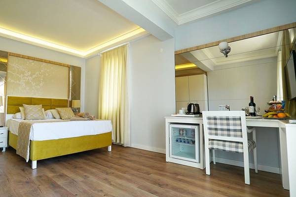 Hotelzimmer im Selectum Family Comfort Side mit Bett, Schreibtisch und Kühlschrank.