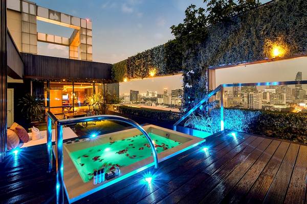 Beleuchteter Jacuzzi auf der Dachterrasse des Pathumwan Princess Hotels mit Blick auf die Stadt
