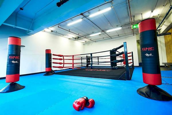 Box-Trainingsbereich im Pathumwan Princess Hotel mit roten Boxhandschuhen und roten Boxständern.