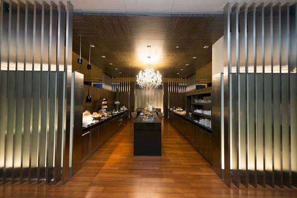 Frühstücksbereich des Pathumwan Princess Hotels mit Holzboden und Buffettischen.
