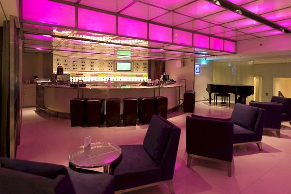 Loungebereich des Pathumwan Princess Hotels mit lila Beleuchtung und modernen Möbeln.