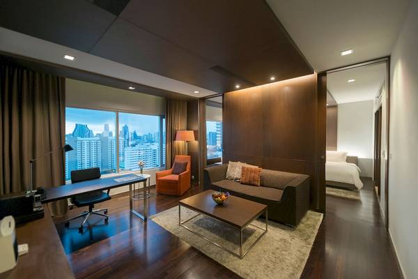 Innenansicht der Suite im Pathumwan Princess Hotel mit Schreibtisch, Sofa und Bett