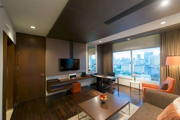Ein modernes Zimmer im Pathumwan Princess Hotel mit Blick auf die Stadt.