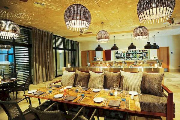 Innenbereich des Sofitel Agadir Thalassa Sea & Spa Hotels mit Esstisch, Stühlen und Bar.