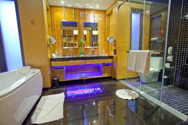 Badezimmer im Ramada Resort by Wyndham Khao Lak mit Badewanne, Waschbecken und Dusche.