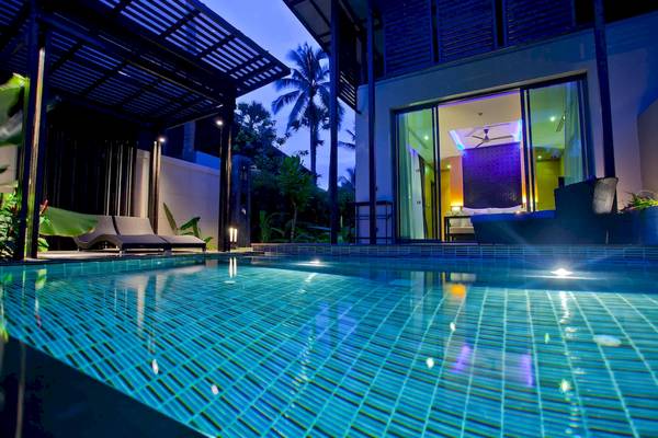 Beleuchteter Swimmingpool des Ramada Resort by Wyndham Khao Lak bei Nacht