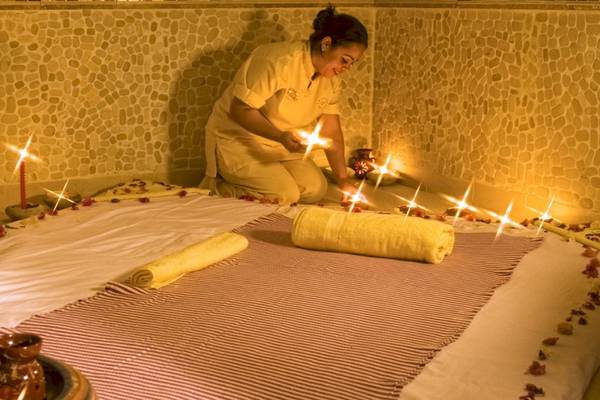 Massage-Behandlung im Djerba Plaza Thalasso & Spa mit entzündeten Kerzen und aromatischen Ölen.