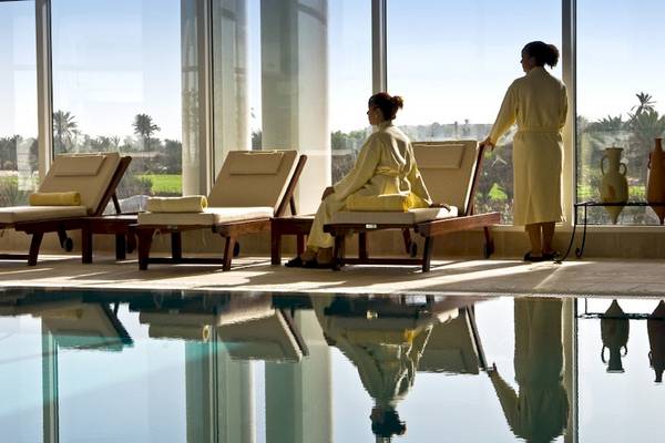 Loungebereich im Djerba Plaza Thalasso & Spa mit zwei Frauen in gelben Bademänteln, die sich entspannen.