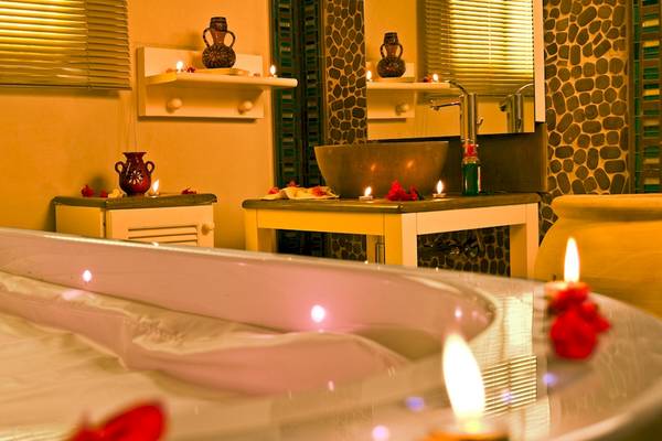 Badezimmer im Djerba Plaza Thalasso & Spa Hotel mit Badewanne, Kerzen und Dekorationen.