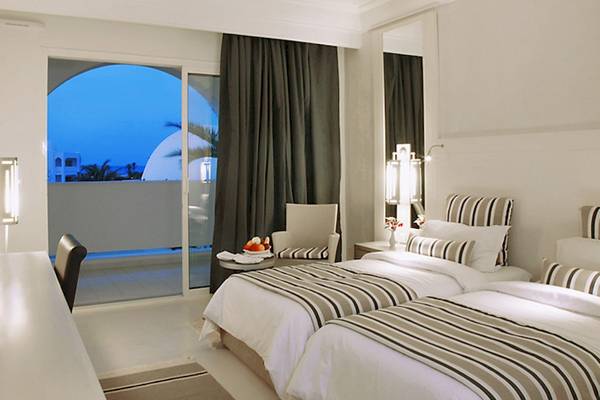 Doppelzimmer im Djerba Plaza Thalasso & Spa Hotel mit Balkon, zwei Betten und Meerblick.