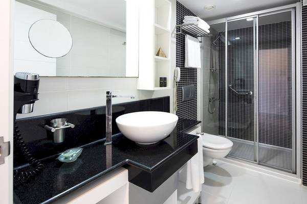 Badezimmer im Voyage Torba Hotel mit Waschbecken, Spiegel und Dusche