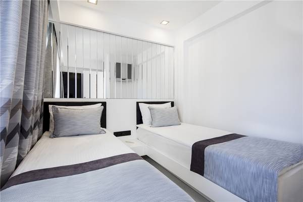 Doppelzimmer im Voyage Torba Hotel mit zwei Betten, weißen Wänden und einer großen Spiegelwand.