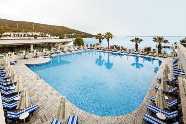 Außenpool des Voyage Torba Hotels mit Blick auf das Meer und die Berge