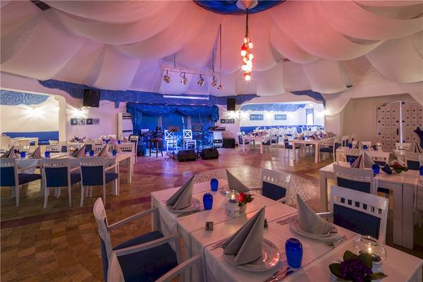 Innenbereich des Voyage Torba Hotels mit blauen und weißen Tischdecken und Tischkarten.