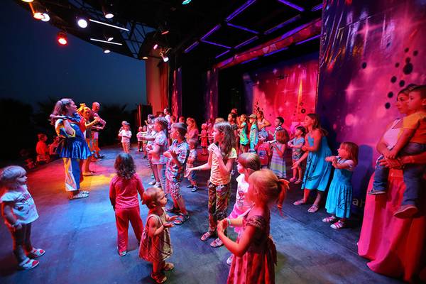 Eine Gruppe von Kindern und Erwachsenen genießt eine Show auf der Bühne im Selectum Family Comfort Side Hotel.