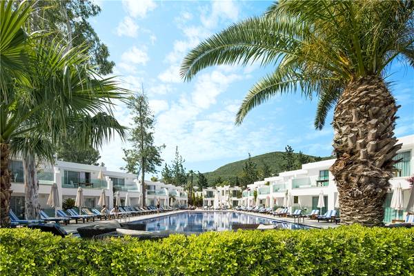 Außenbereich des Voyage Torba Hotels mit Swimmingpool und Sonnenliegen.