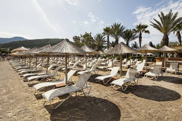 Strand des Voyage Torba Hotels mit vielen Sonnenliegen und Sonnenschirmen